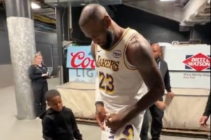 這個我也想要！小球迷拿著詹姆斯球衣 后者特意停步為他送上親簽